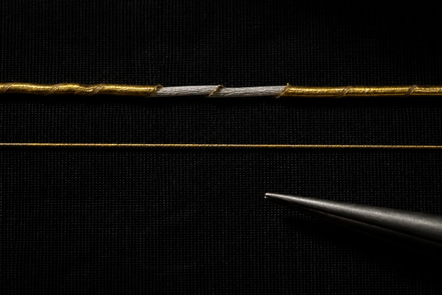 A damaged foil-wrapped imitation thread compared with an intact gold-bonded fibre